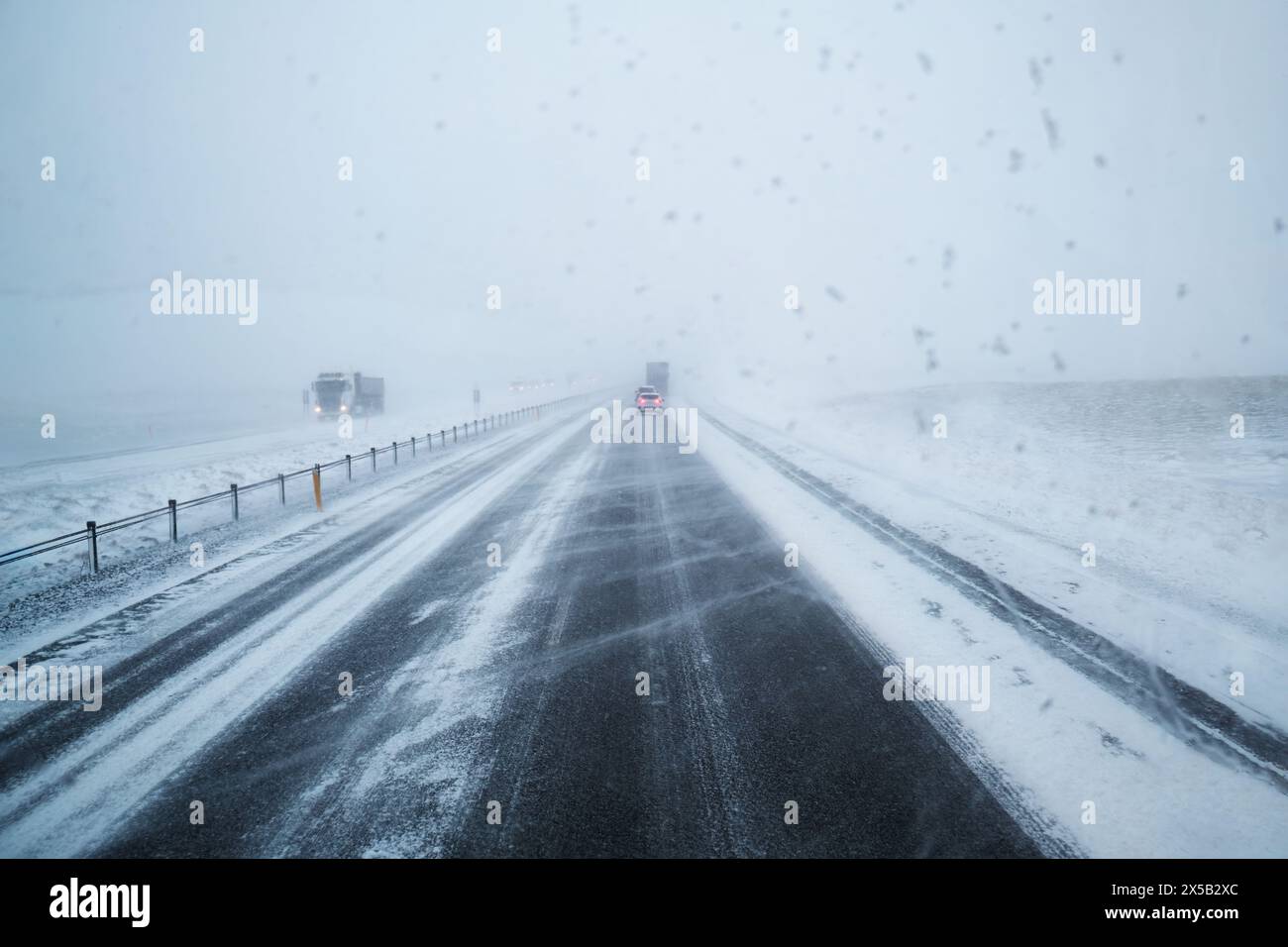 Car driving on snow covered highway road and blizzard with windy in ...