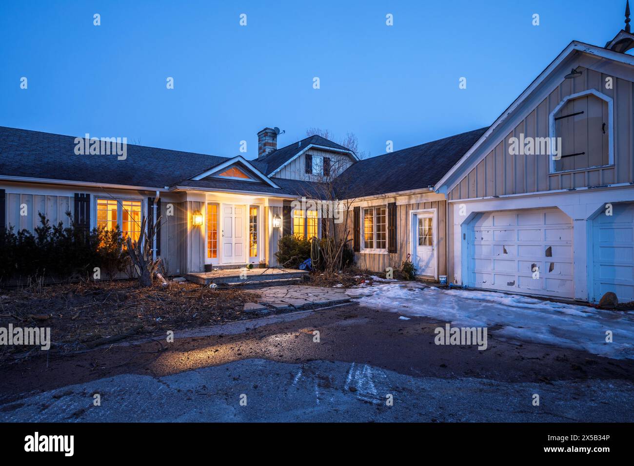 A large abandoned house illuminated at dusk. This house has since been demolished. Stock Photo