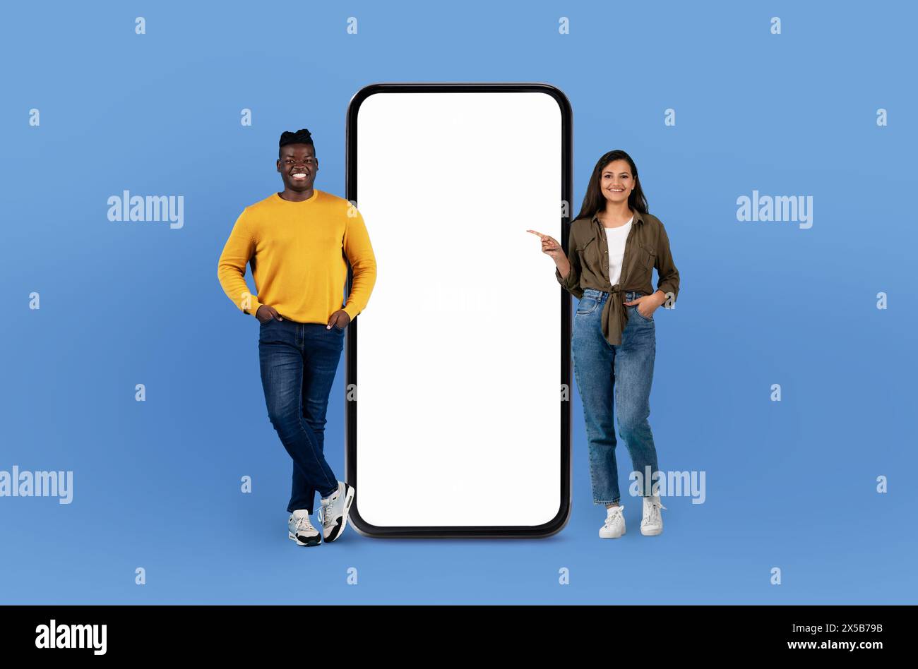 Two People Standing Next to a Large Phone Stock Photo