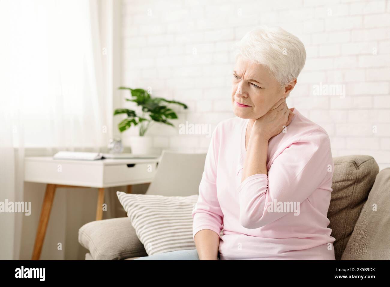 Mature woman suffering from backache at home Stock Photo