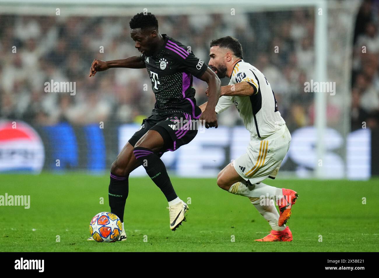 Madrid, Spain. 08th May, 2024. Alphonso Davies of Bayern Munchen and Daniel Carvajal of Real Madrid during the UEFA Champions League match, Semi-finals, 2nd leg, between Real Madrid and FC Bayern Munchen played at Santiago Bernabeu Stadium on May 8, 2024 in Madrid Spain. (Photo by Sergio Ruiz/PRESSINPHOTO) Credit: PRESSINPHOTO SPORTS AGENCY/Alamy Live News Stock Photo