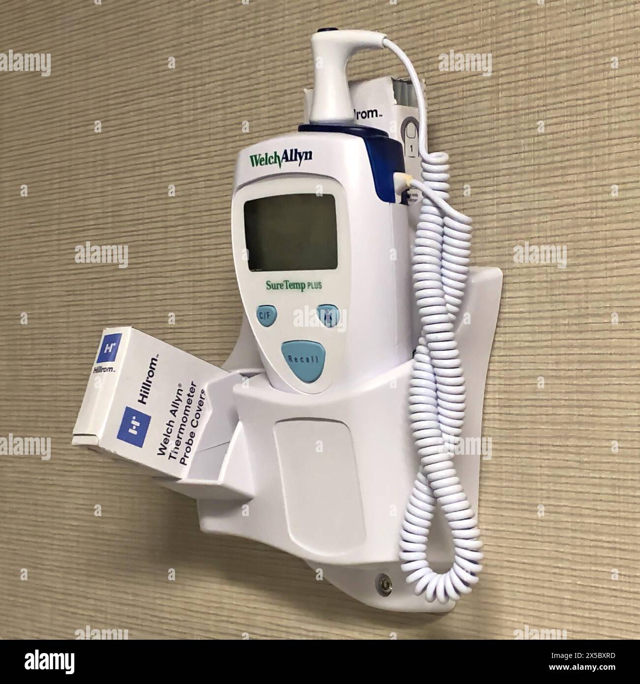 ROCHESTER, MN - 27 JUL 2020: Medical thermometer in doctors office mounted on wall in exam room. Electronic healthcare equipment. Stock Photo