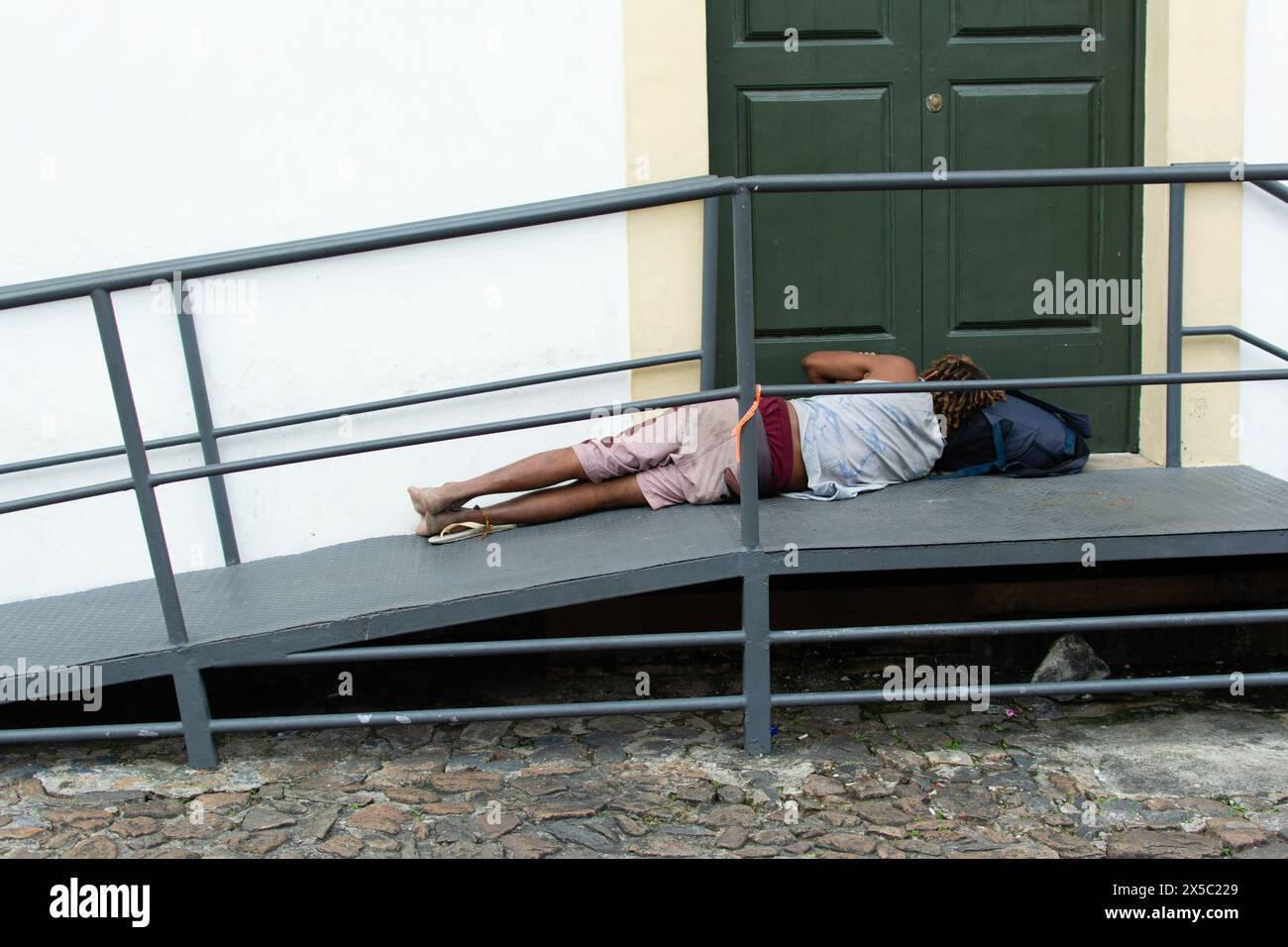 Salvador, Bahia, Brazil - July 27, 2019: Homeless man is seen sleeping on an access ramp in Pelourinho, historic center of the city of Salvador, Bahia Stock Photo