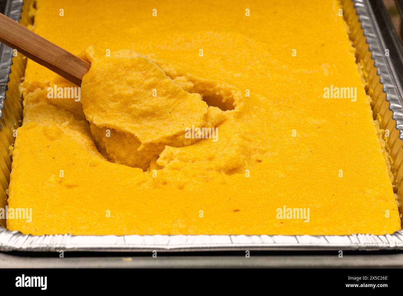 Polenta corn traditional food in an aluminum steam table pan. Party catering concept. Stock Photo