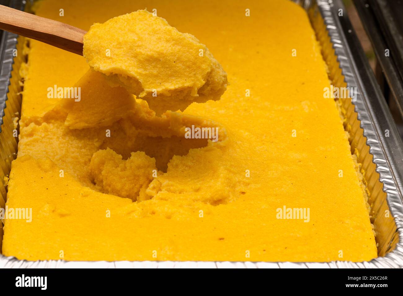 Polenta corn traditional food in an aluminum steam table pan. Party catering concept. Stock Photo