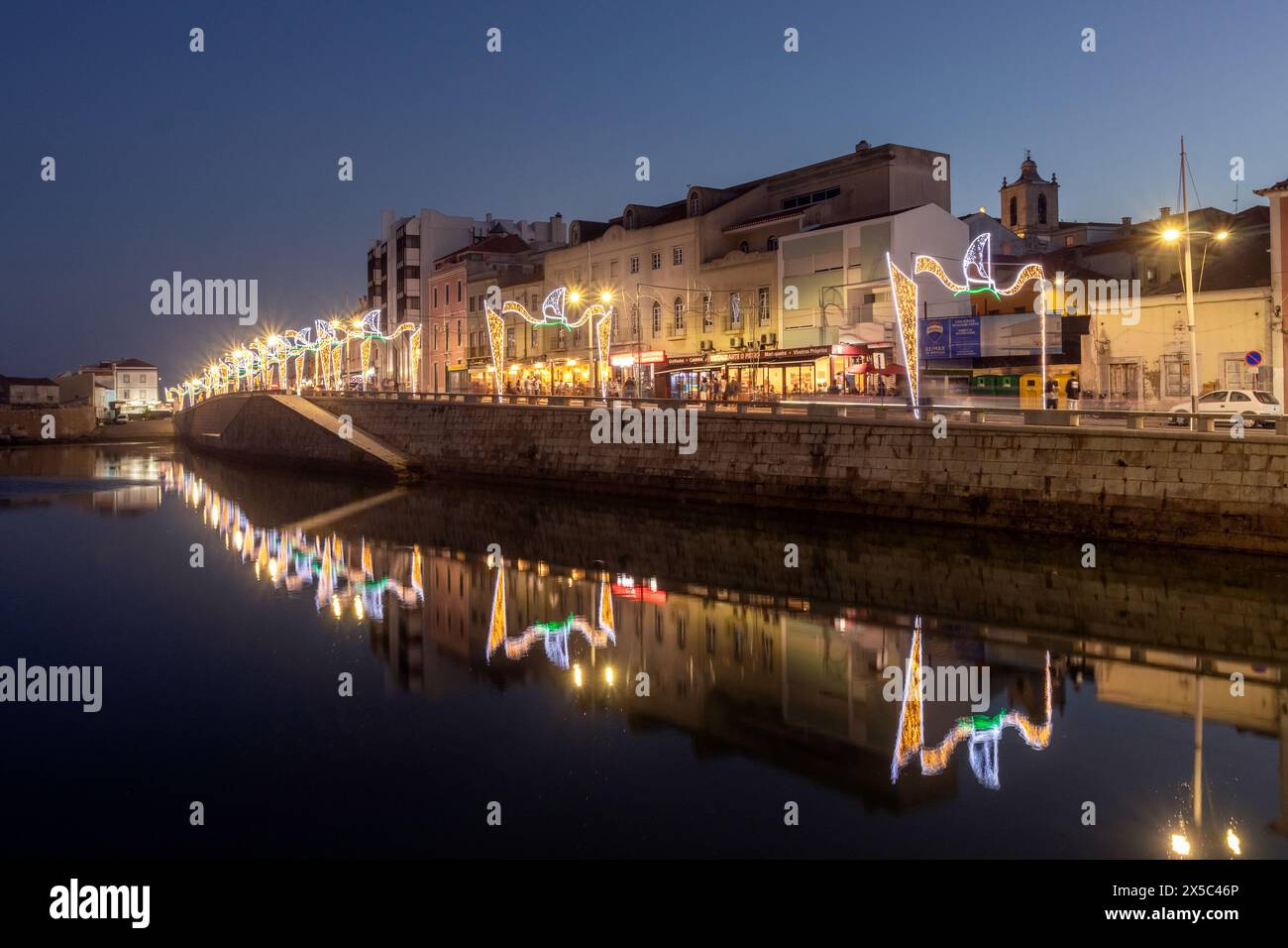 Peniche, Portugal - August 09, 2023: Restaurant street in Peniche, Portugal, seen at dusk with party lights and reflections in the water. Stock Photo