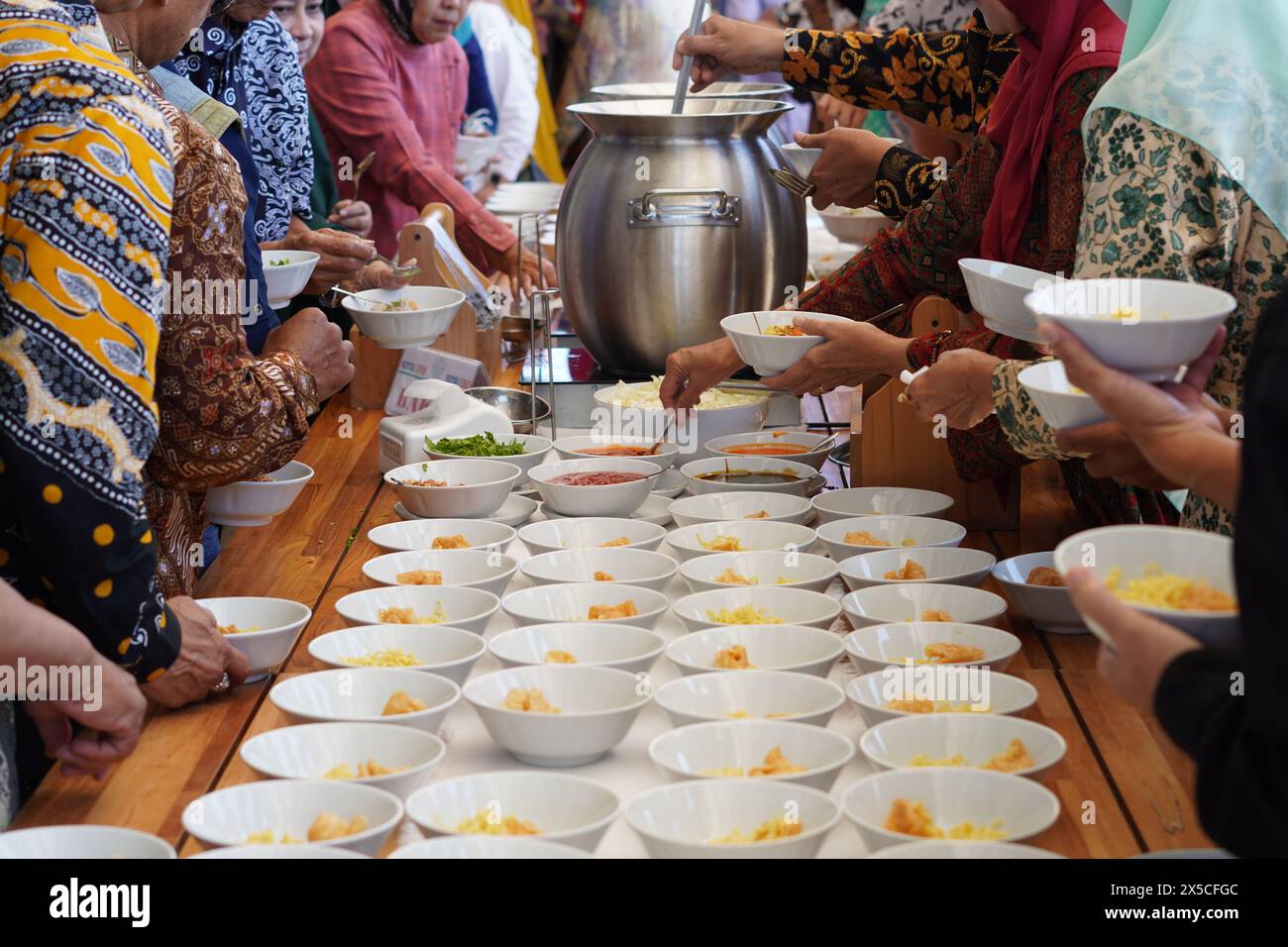 People taking food from a buffet at an event in Indonesia Stock Photo