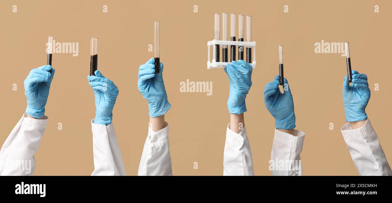 Scientist's hands holding test tubes with soil on brown background ...