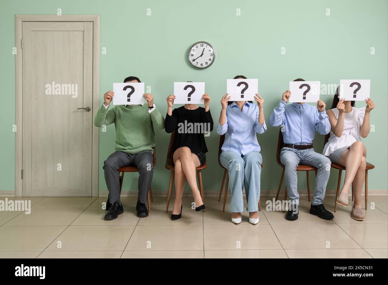 Waiting Questions Young people holding paper sheets with question marks while waiting for ...