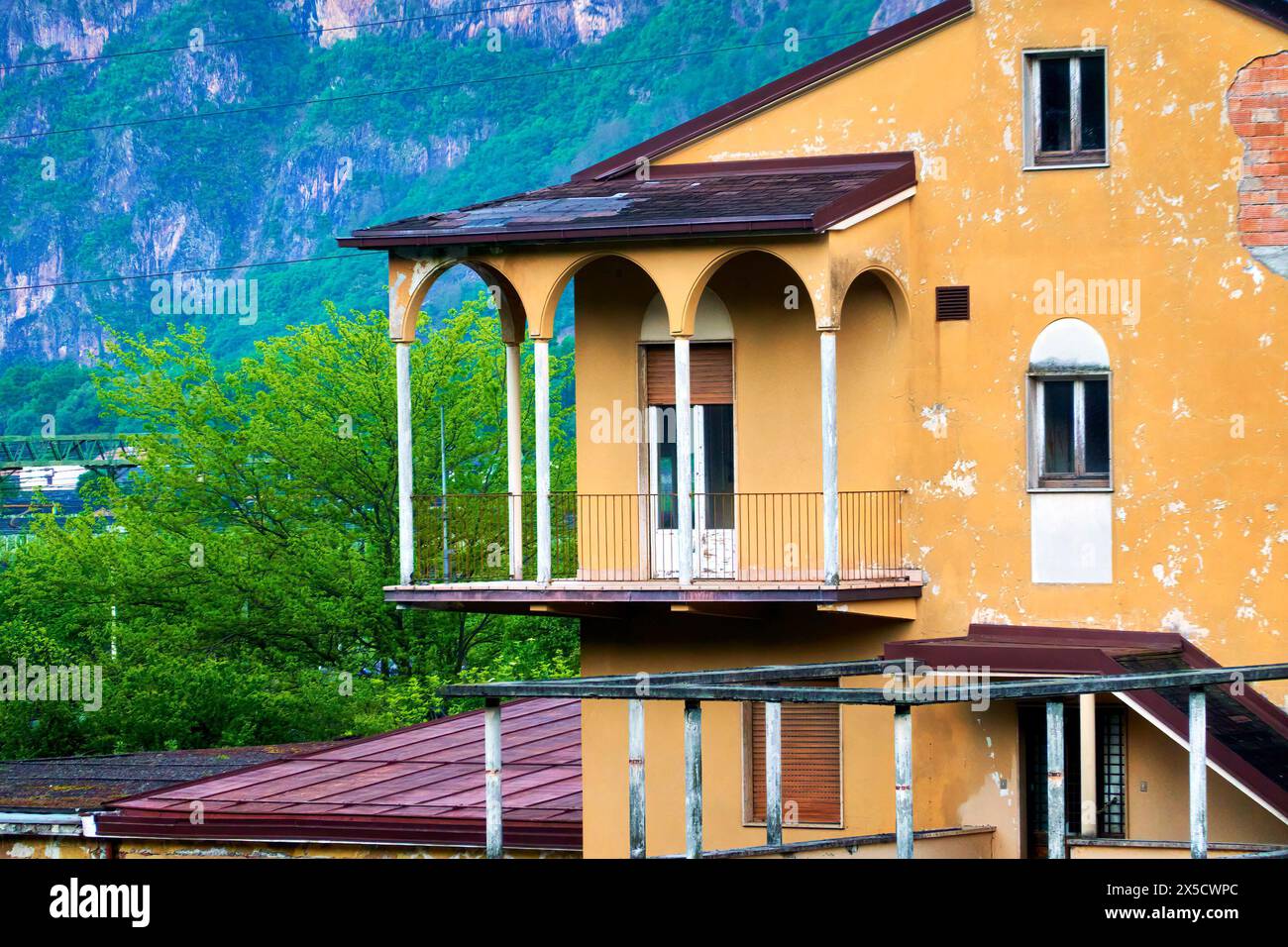 Bozen, Italy, April 14, 2024: Aging Italian villa with yellow peeling paint Stock Photo