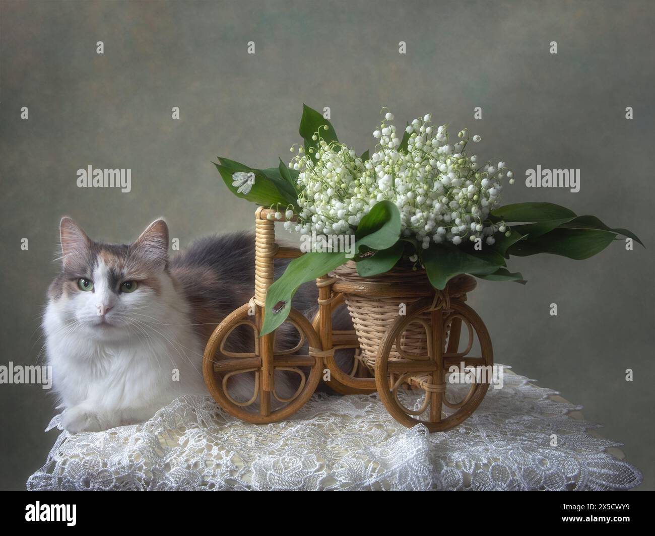 Basket with lily of the valley and pretty kitty Stock Photo - Alamy