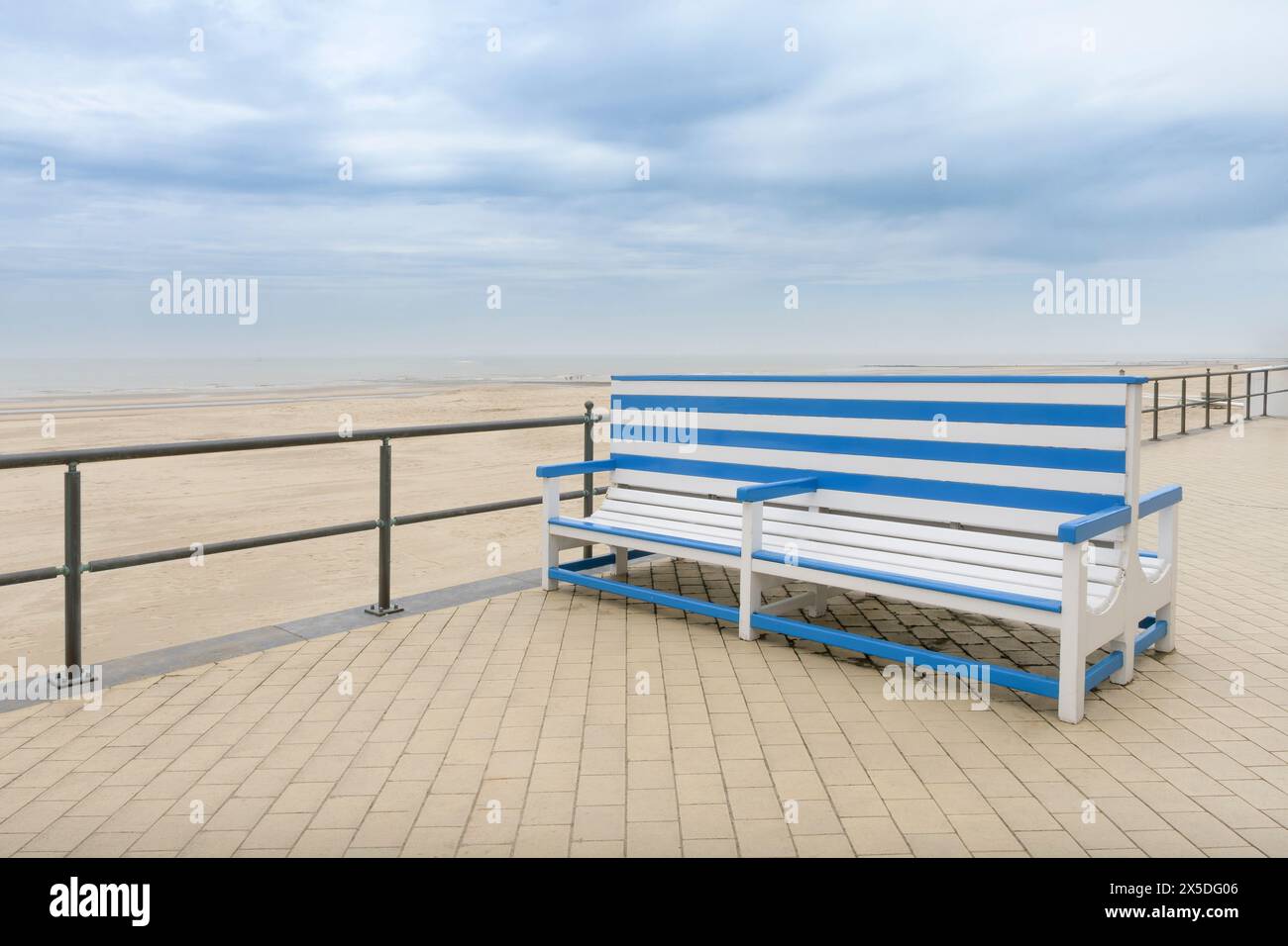 A large beautiful bench on a deserted autumn sea beach at sea. White-blue striped color. Copy space. concept Stock Photo