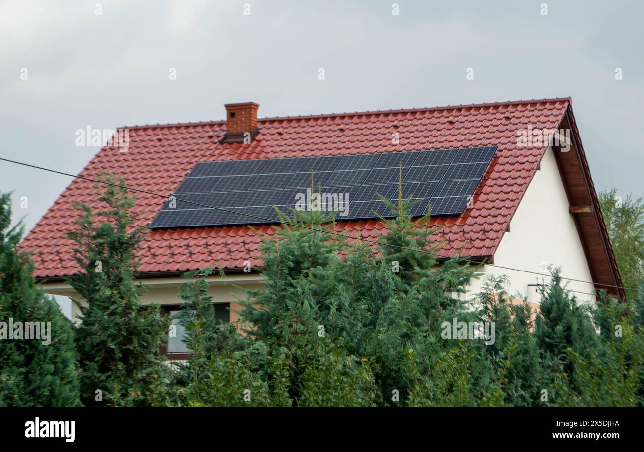 View of House roof with photovoltaic modules. Historic farm house with modern ...