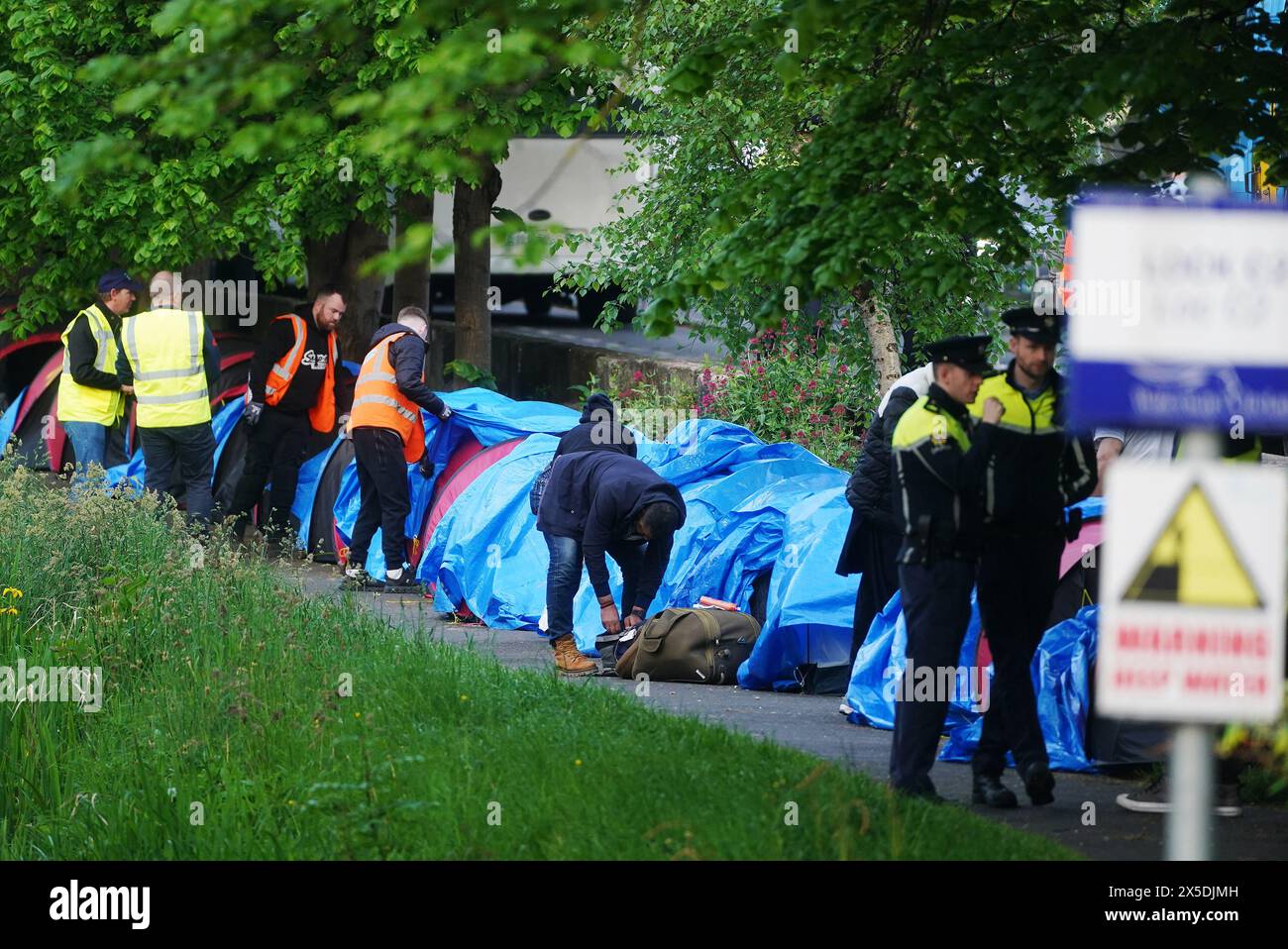 An early morning operation to remove tents which have been pitched by asylum seekers along a stretch of the Grand Canal, Dublin. The asylum claimants moved into the area after another makeshift migrant camp surrounding the International Protection Office (IPO) on Mount Street, Dublin, was dismantled in multi-agency operation last week. Picture date: Thursday May 9, 2024. Stock Photo
