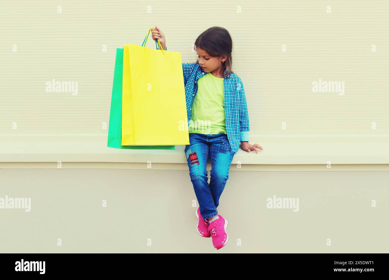 Little girl child with colorful shopping bags posing on city street ...