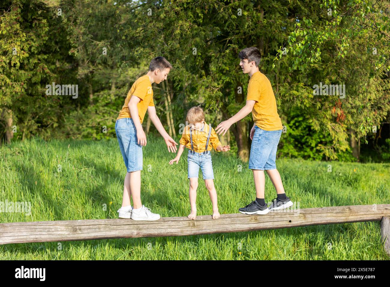 Happy family with kids and pet dog in the park, enjoying day together on sunset Stock Photo