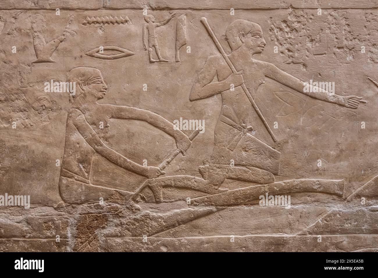 Egyptian bas-relief sculpture showing two men rowing out to fish for food. Pyramid of Unas, in the Necropolis of Saqqara, Egypt. Stock Photo