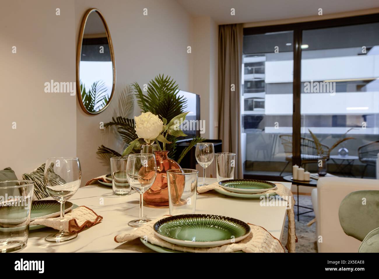 Dining table in a living room with glassware and cutlery prepared. Stock Photo