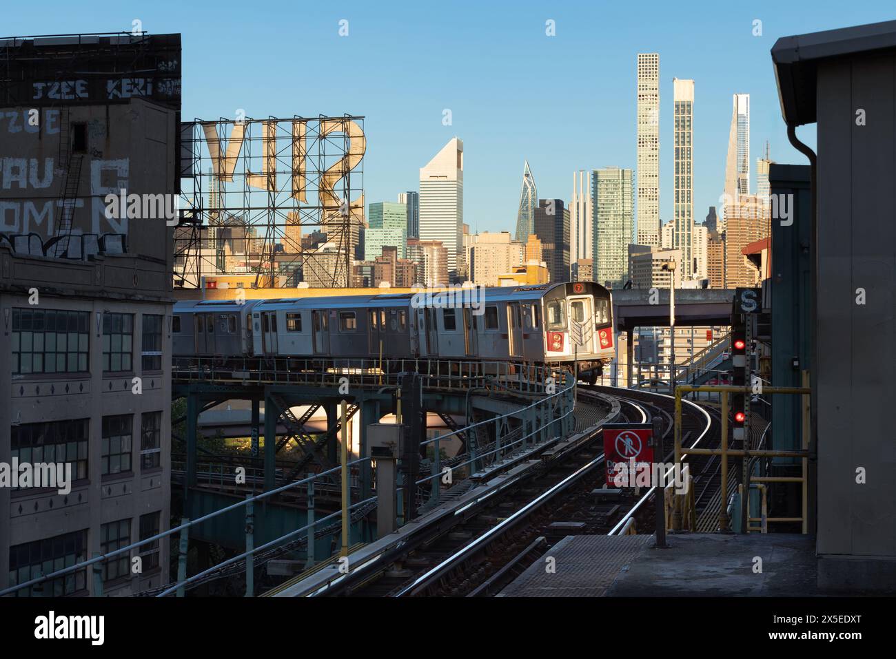 New York City, Number 7 train and elevated subway tracks in Long Island City with morning view of the skyscrapers of Upper East Side (Manhattan) Stock Photo