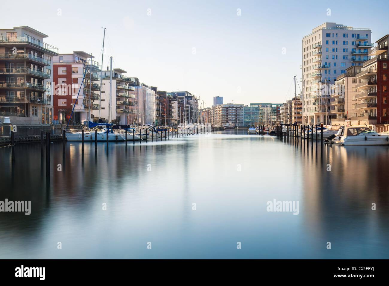 Serenity meets urban growth at a Dockan Marina in Malmö, where boats dock in calm waters . Concepts: urban expansion, waterfront living, Malmö Stock Photo