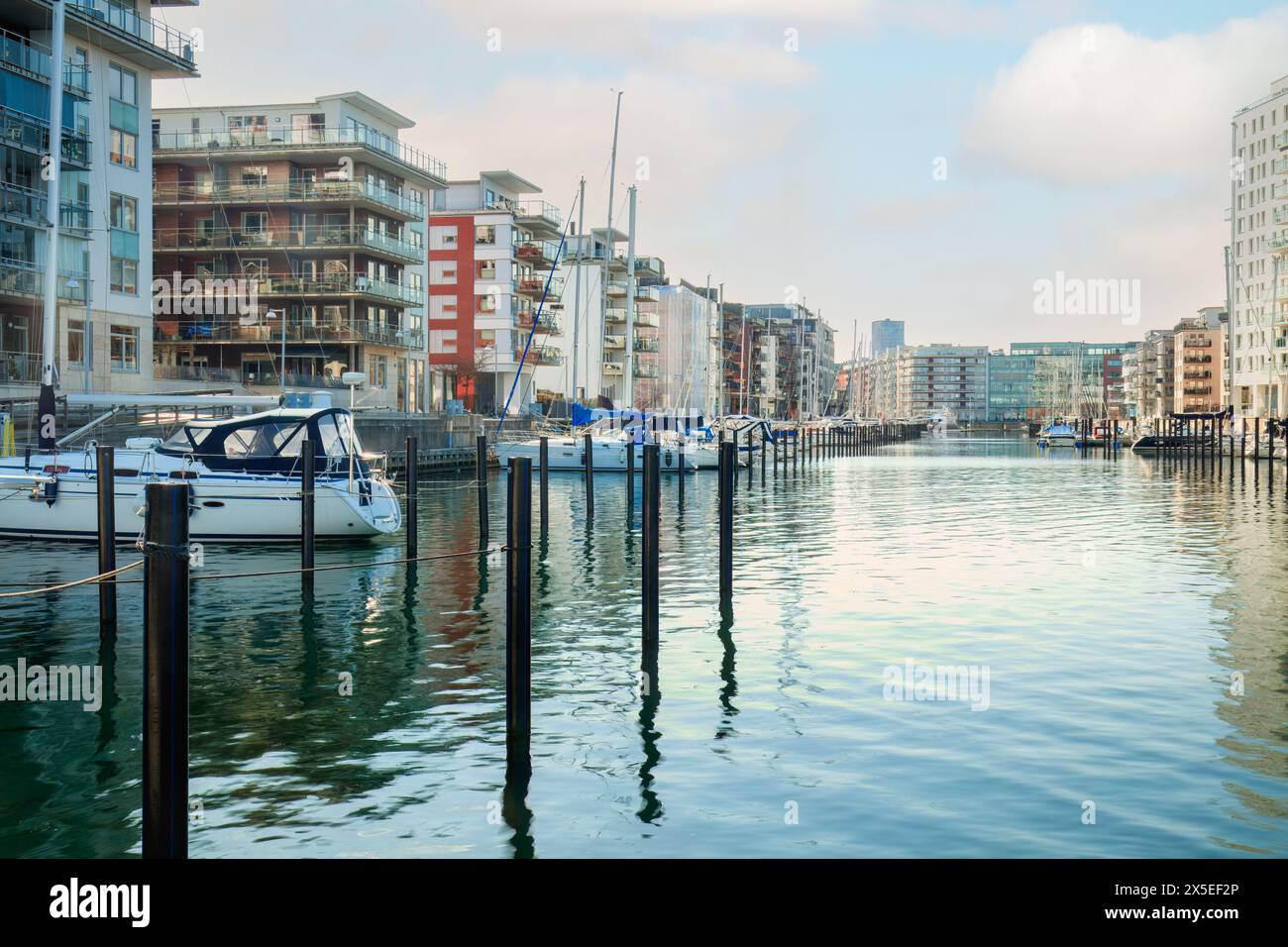 Boats and modern buildings at a Dockan Marina in Malmö, where boats dock in calm waters . Concepts: urban expansion, waterfront living, Malmö Stock Photo