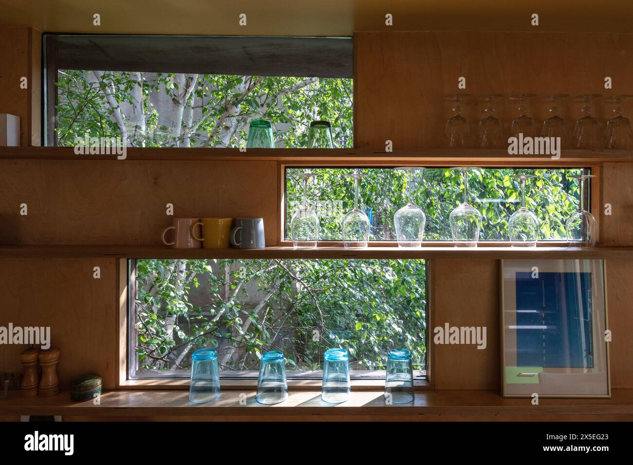 Oblong windows run down the side of the kitchen area. Straw Bale House