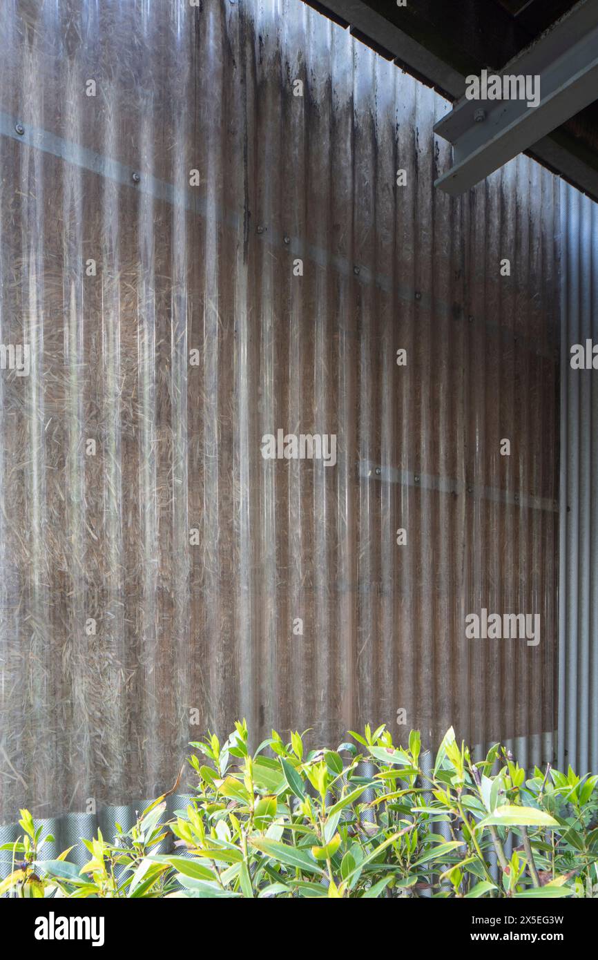 Detail of the corrugated plastic sheeting with the straw bales behind