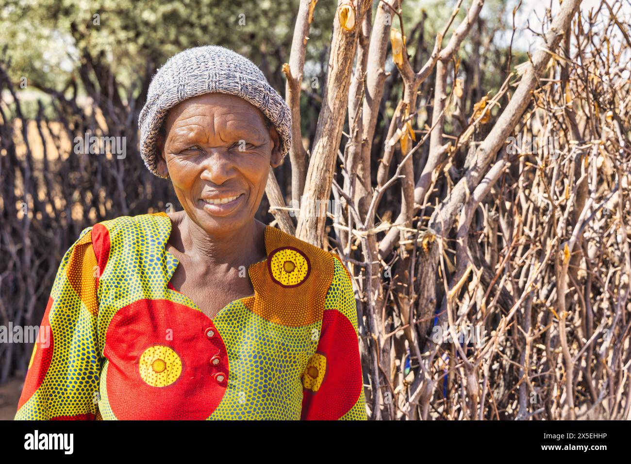 African village, single happy granny woman with a big smile wrinkles standing in front of the