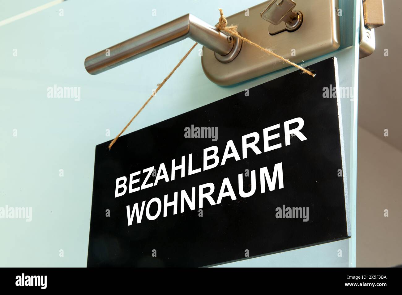 Sign with the german inscription BEZAHLBARER WOHNRAUM (affordable housing) on a door (symbolic image) Stock Photo