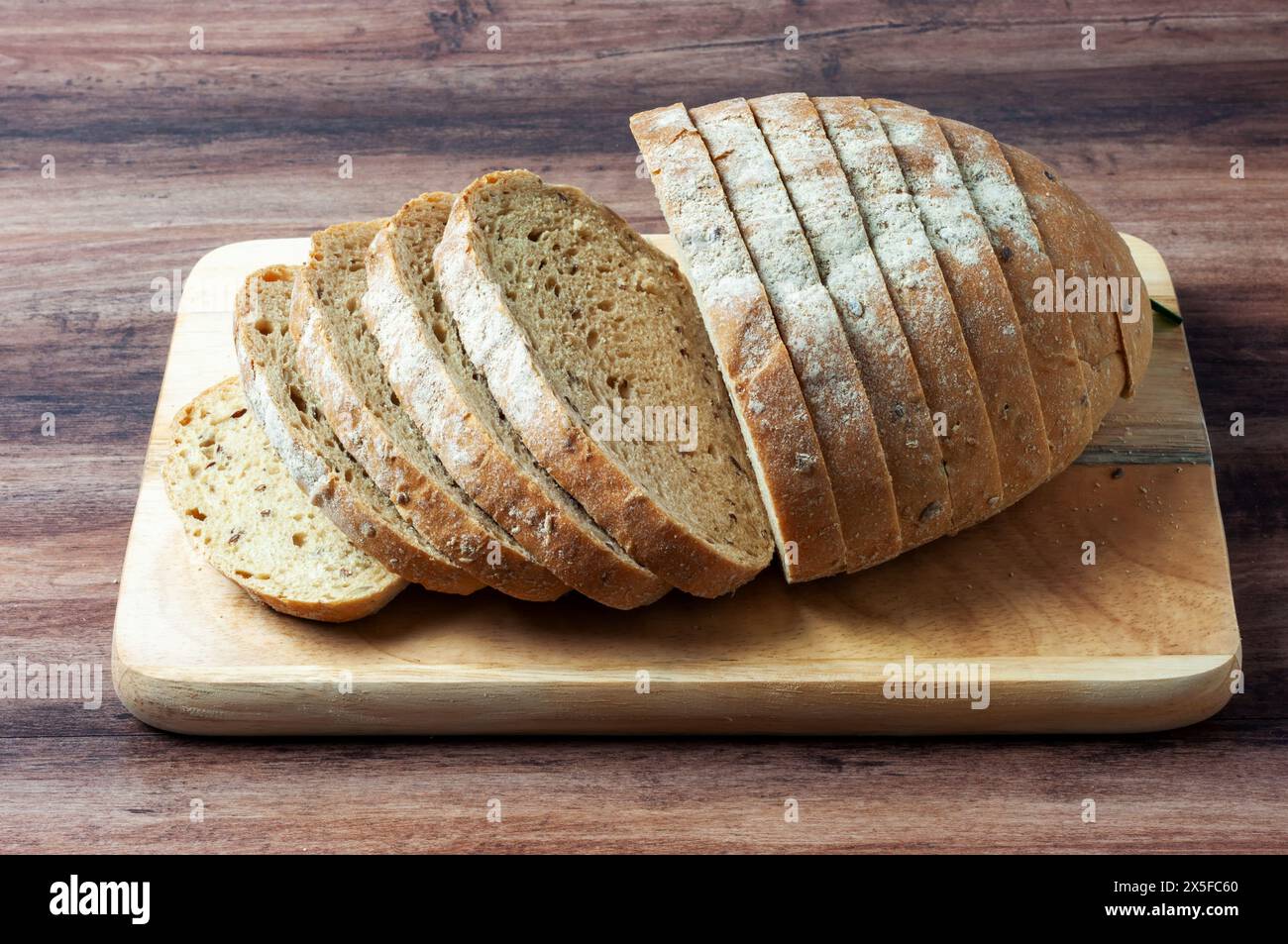 Loaf of multigrain bread on a wood tray Stock Photo