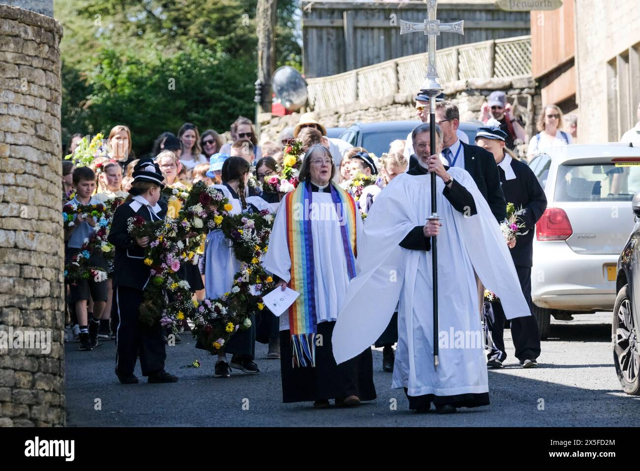 Bisley, Glos, UK. 9th May, 2024. In a traditional Cotswold activity, children from Blue Coat primary school celebrate Ascension Day by parading through the village. The children are wearing traditional Victorian style uniforms. Flower garlands are carried to the Wells which they then decorate. The tradition started in 1863 when the Vicar, the Reverend Keble gave thanks for the villages clean water. Credit: JMF News/Alamy Live News Stock Photo