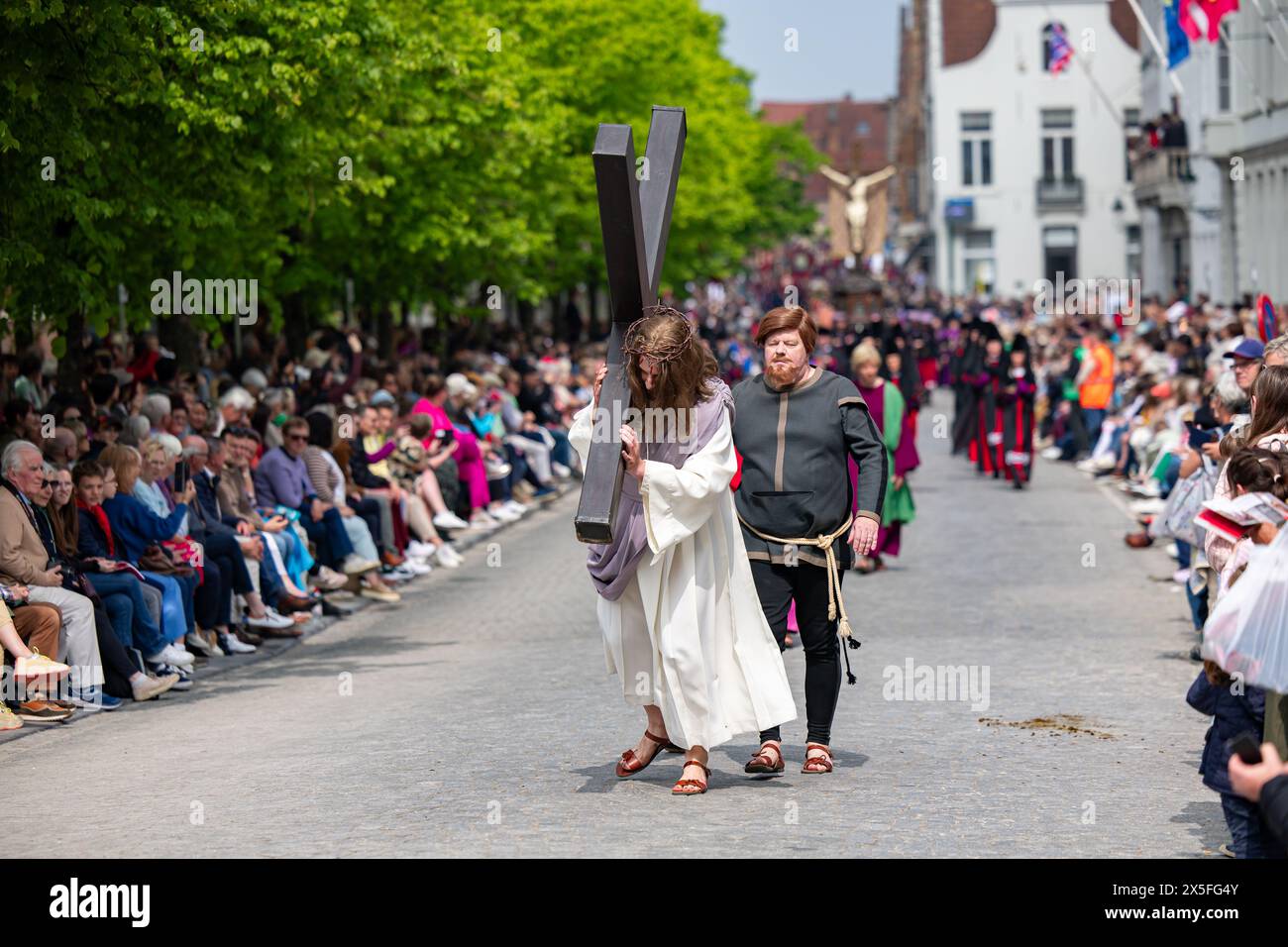 Brugge, Belgium. 09th May, 2024. A volunteer dressed up as Jesus carries a heavy wooden cross during the Holy Blood Procession (Heilige Bloedprocessie - Procession Saint-Sang) event, on Thursday 09 May 2024 in Brugge. During the procession, the relic of the Holy blood is carried from the Holy blood basilica to the Holy Saviour cathedral through the city center of Bruges. BELGA PHOTO KURT DESPLENTER Credit: Belga News Agency/Alamy Live News Stock Photo