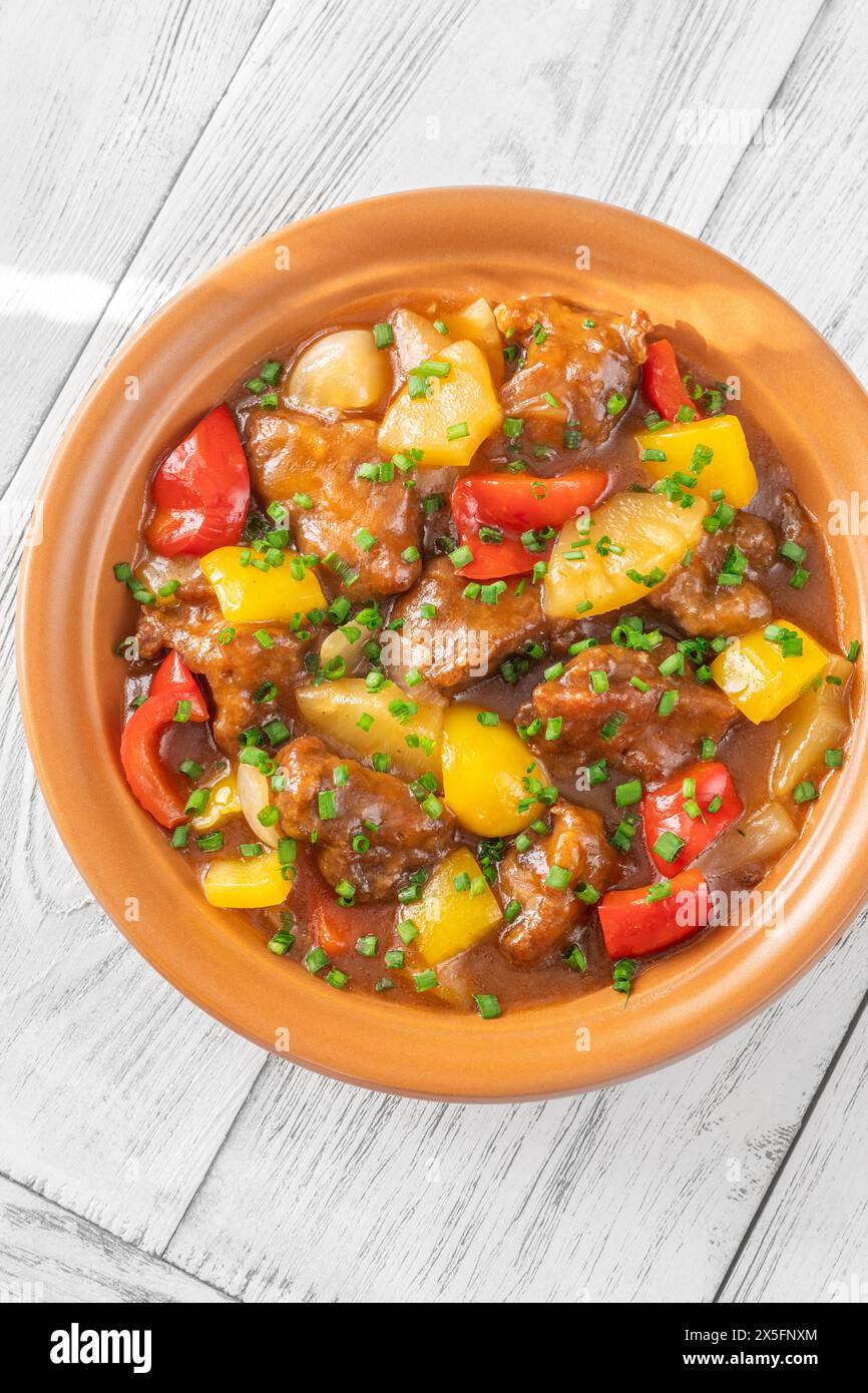 Portion of sweet and sour pork with bell pepper and pineapple Stock Photo