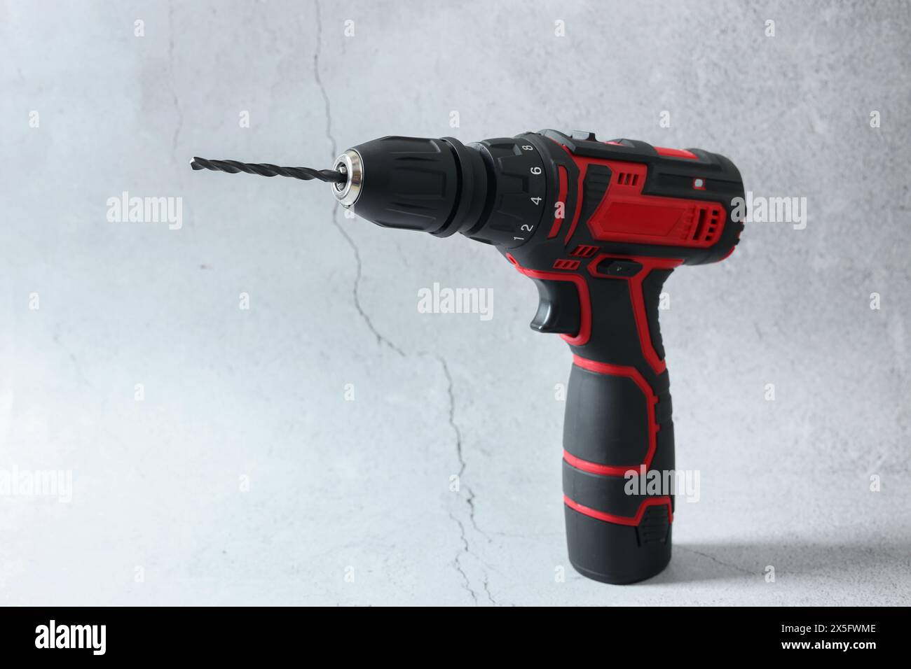 Modern cordless electric screwdriver on light table Stock Photo