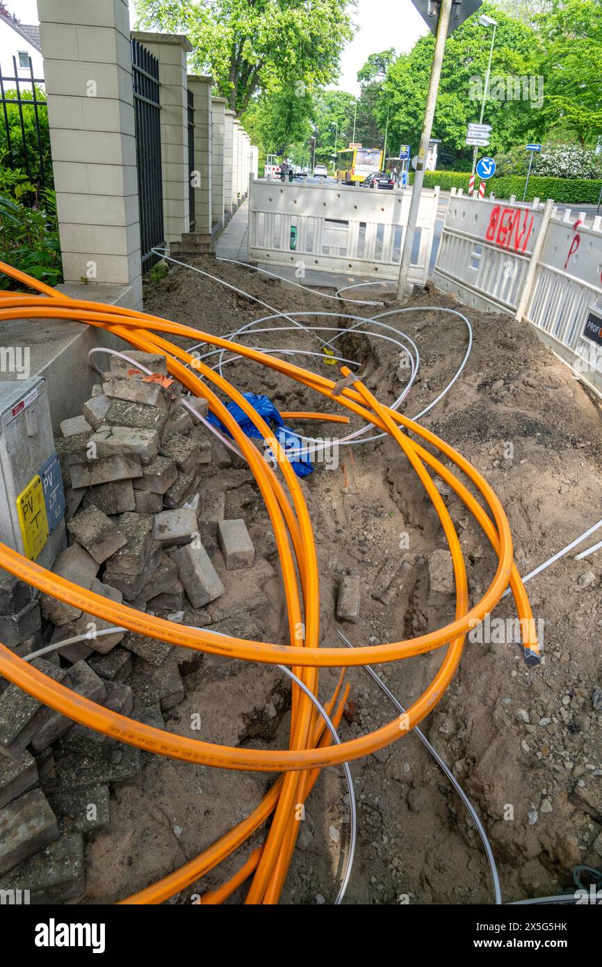 Laying of fiber optic cables, empty conduits are laid under a sidewalk, in which the actual fiber optic cable is later blown in and connected to the r Stock Photo