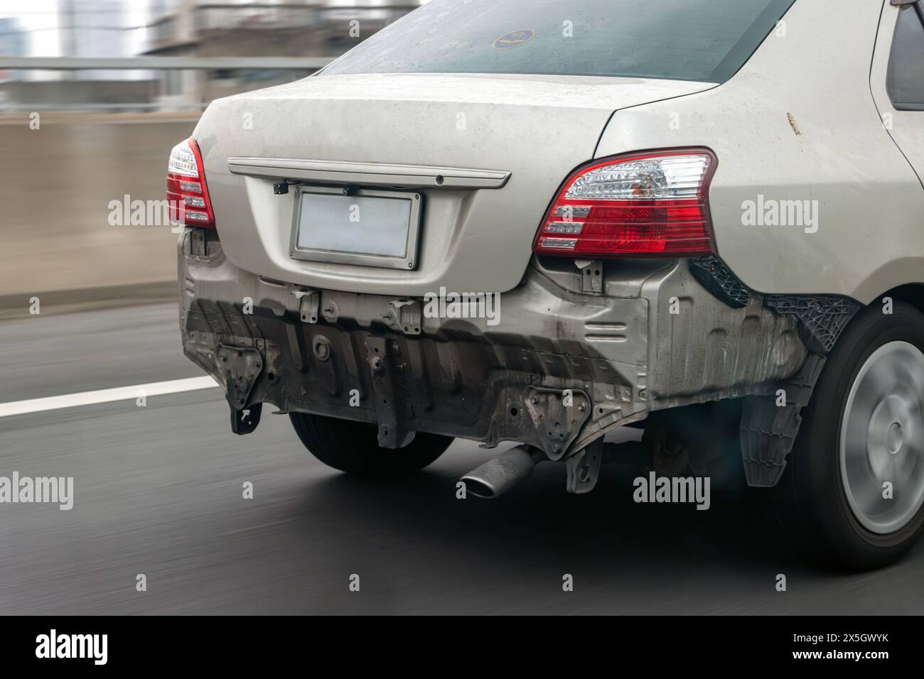 A car is driving on the road without a rear bumper Stock Photo