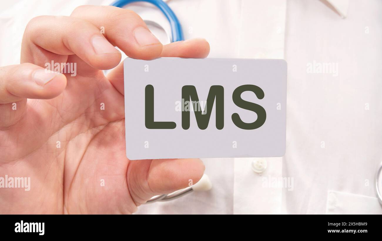 Word cloud concept. LMS - Learning Management System acronym the inscription on the business card is in the hands of a man in a white shirt Stock Photo