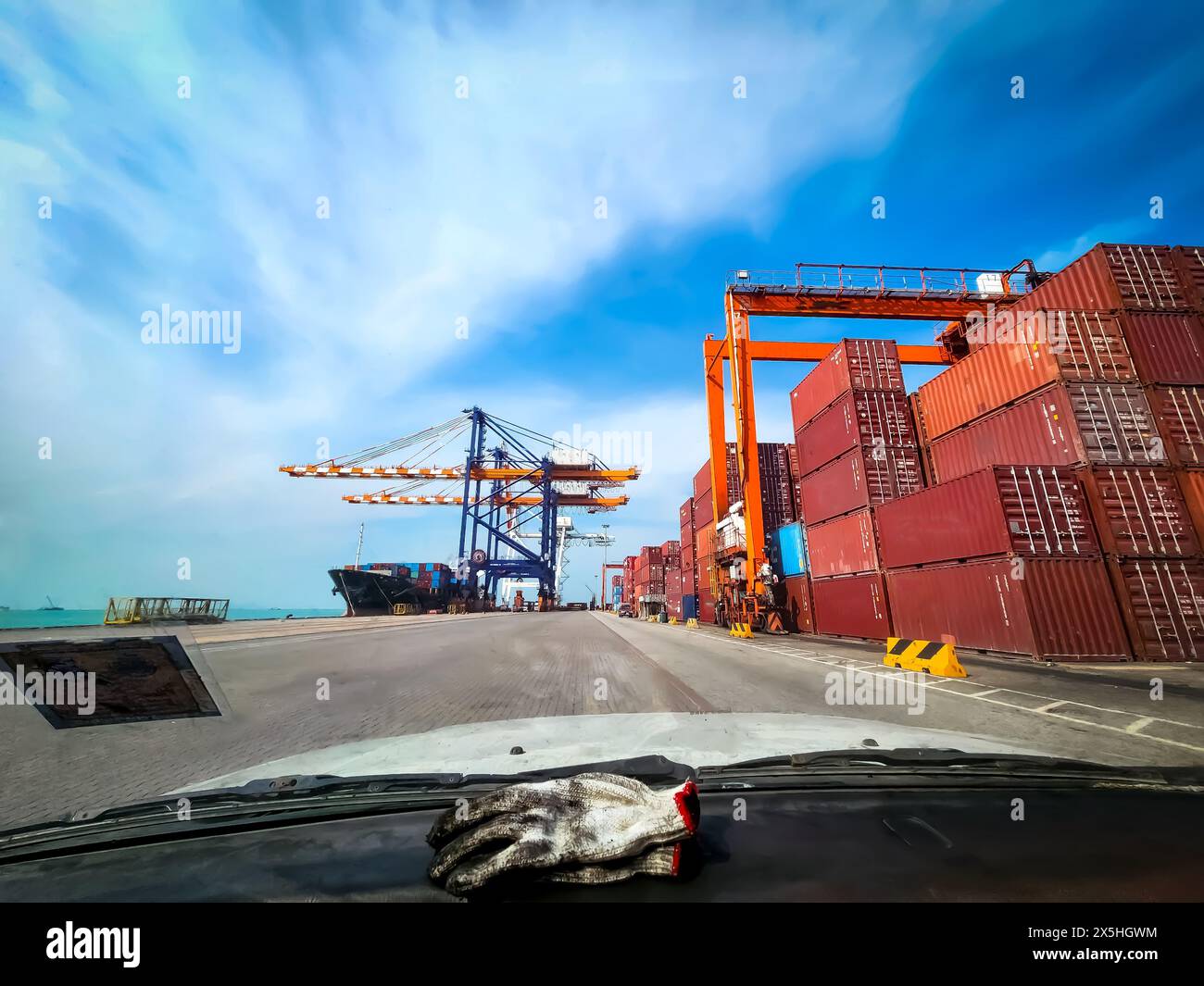 about technician survey on the port road, where there are containers, overhead cranes, and transportation Stock Photo