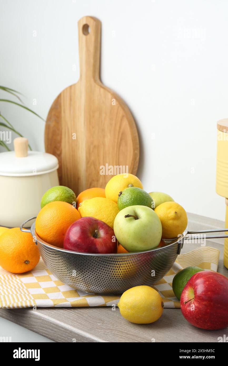Metal colander with different fruits on countertop in kitchen Stock ...