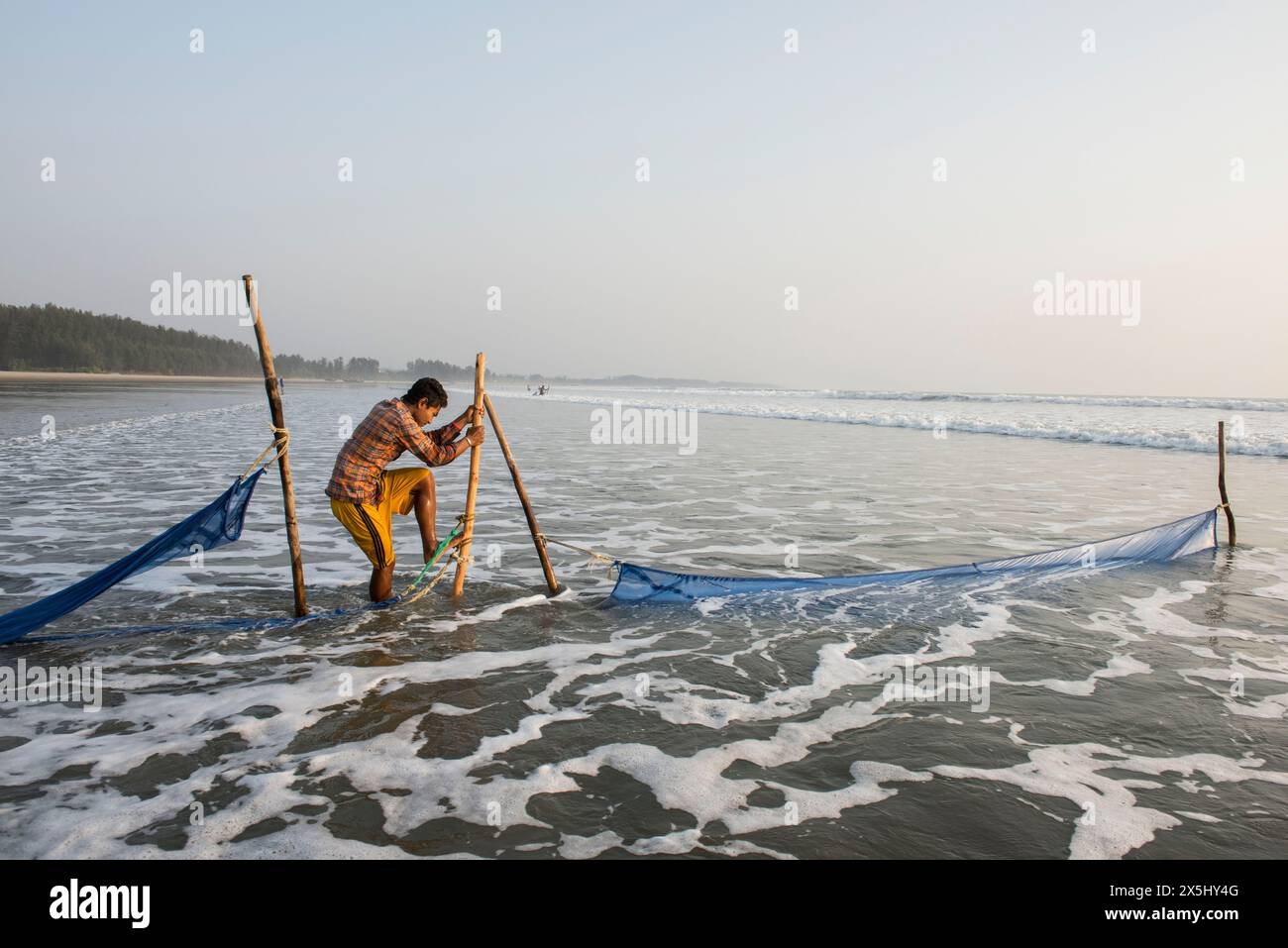 Bangladesh, Cox's Bazar. A fishermen spreads nets in the longest unbroken sea beach in the world. (Editorial use only) Stock Photo