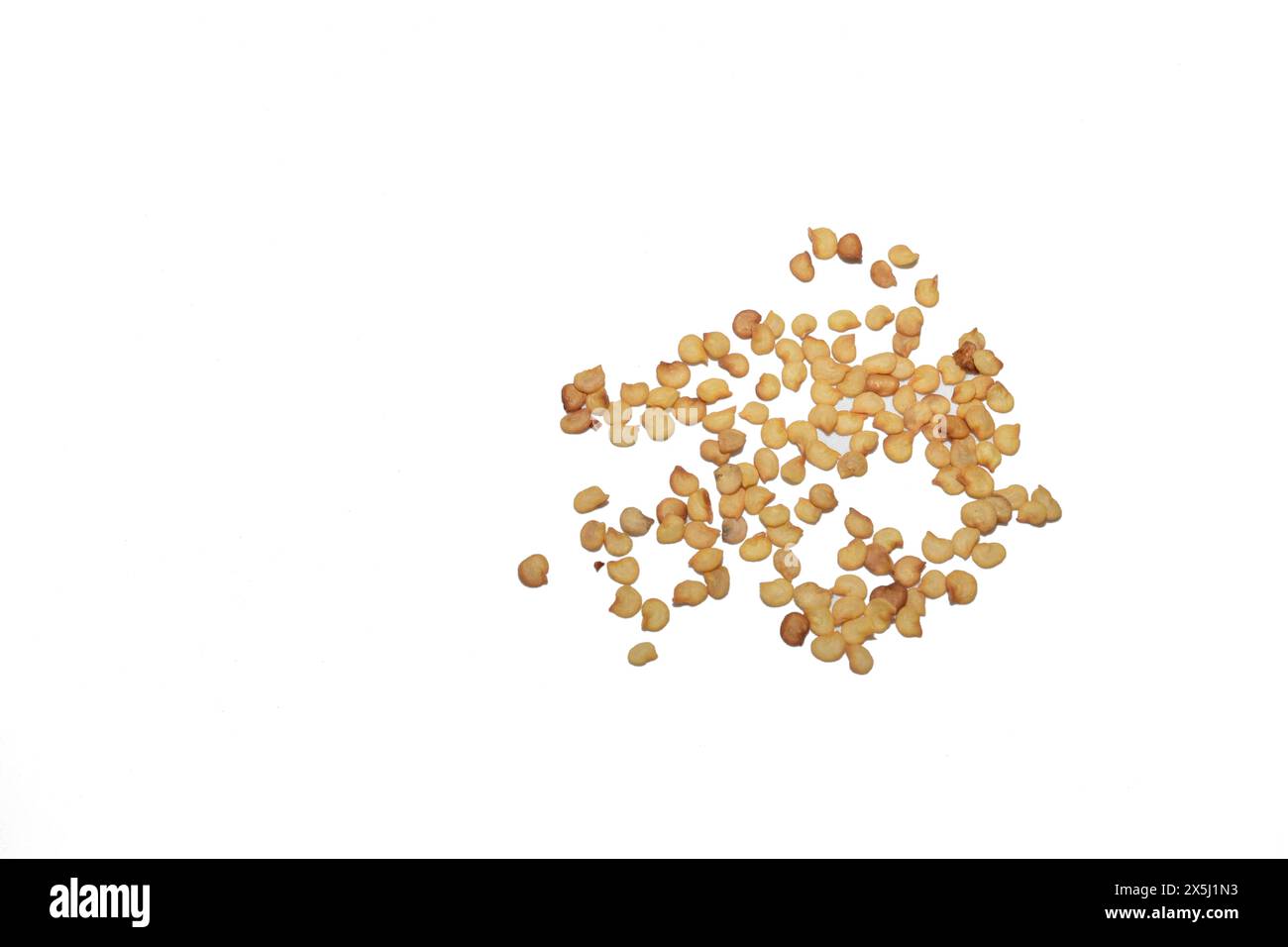 Pepper seeds lie in a small pile on a white background, ready for planting in the garden. Stock Photo