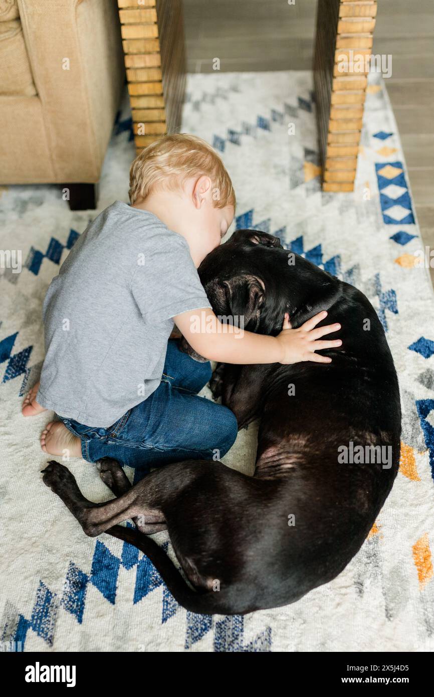 Heartwarming Moment: Toddler Cuddles Loyal Canine Companion Stock Photo