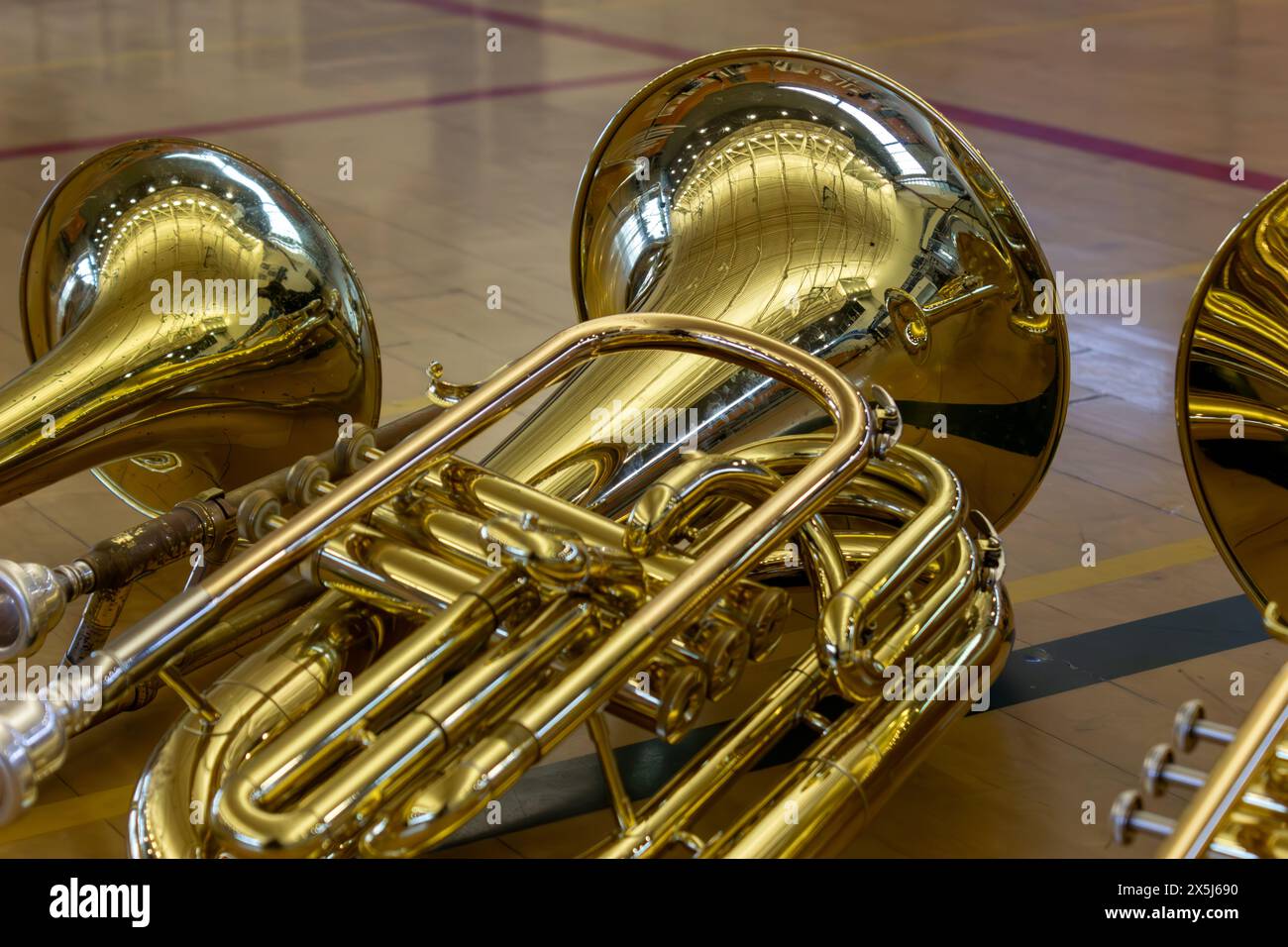 Baritone Lies Next to Other Brass Instruments on Basketball Court. Stock Photo