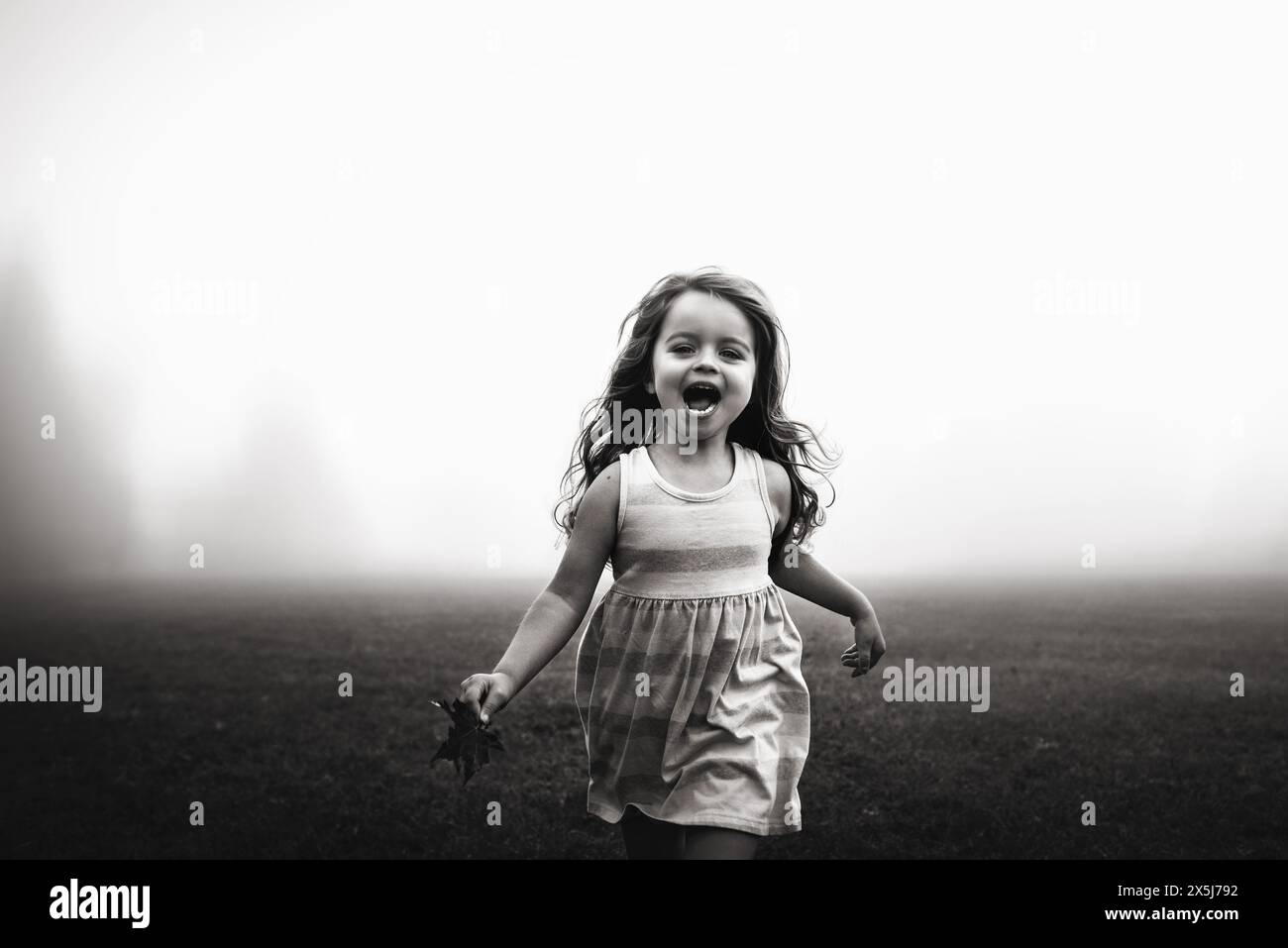 Happy little girl running with leaf in hand Stock Photo - Alamy