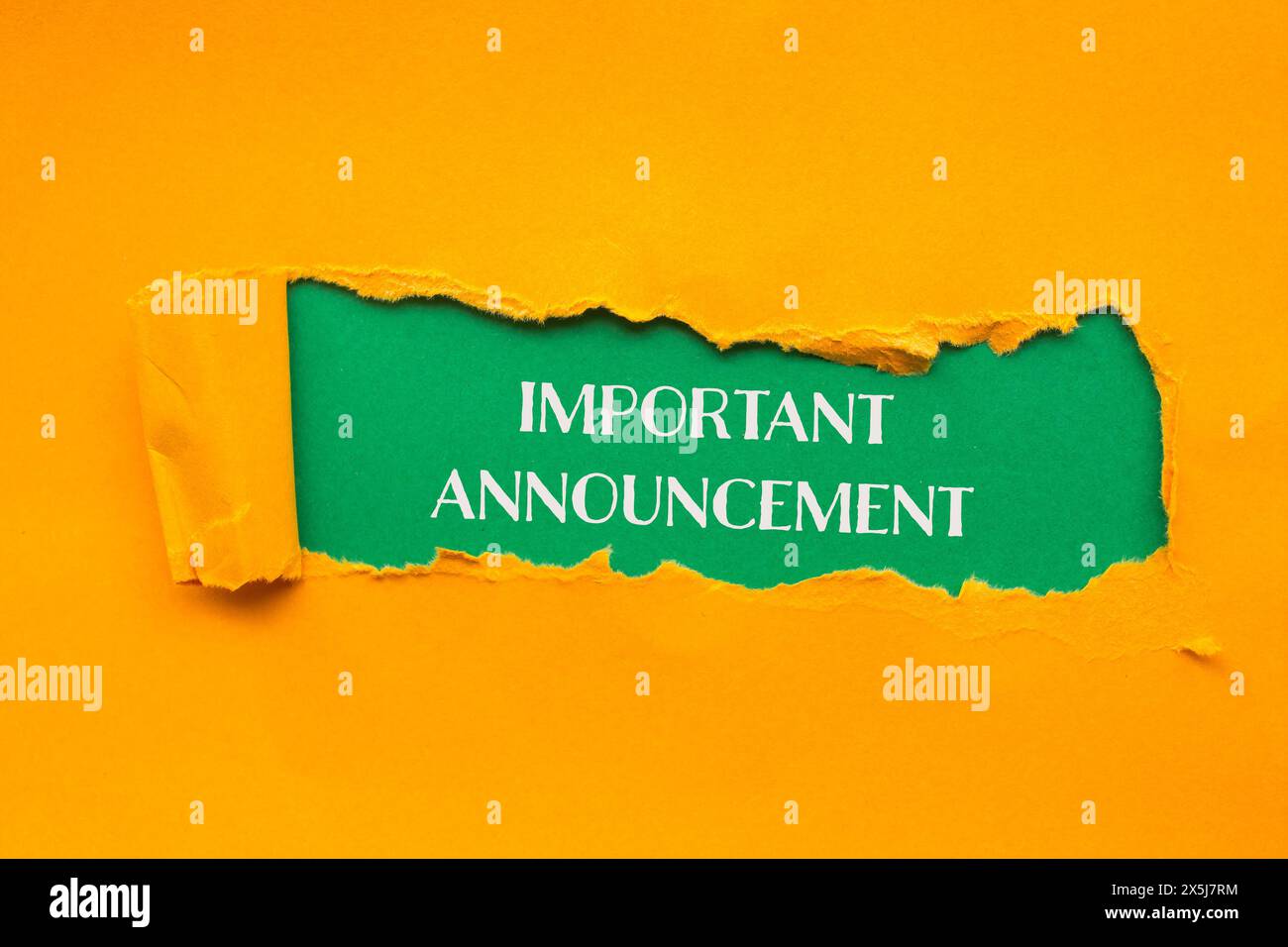Important announcement words written on torn orange paper with green background. Conceptual important announcement  symbol. Copy space. Stock Photo