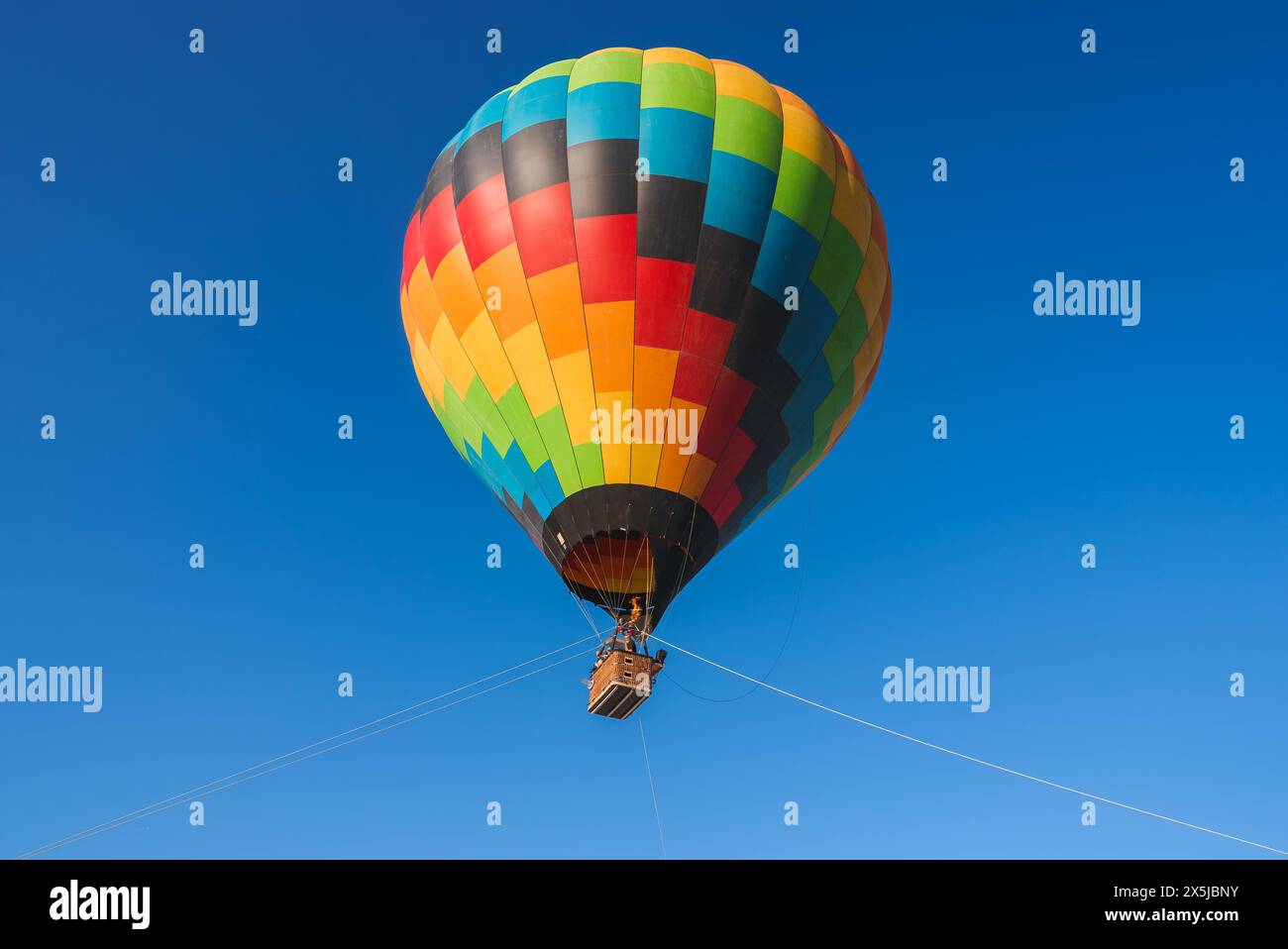Vibrant hot air balloon in desert festival, fly among colorful clouds ...