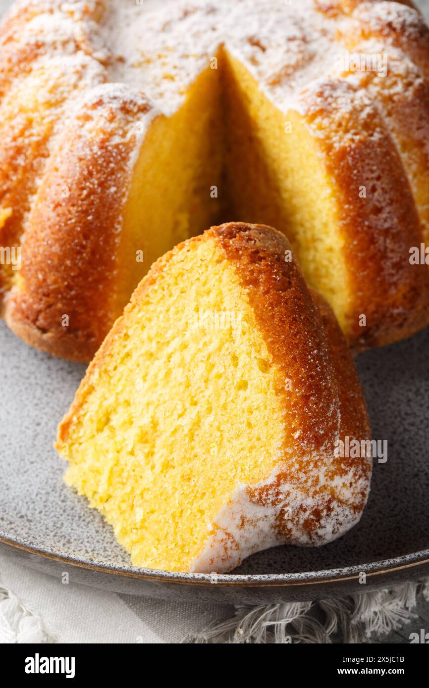 Citrus Orange Pound Cake sprinkled with powdered sugar close-up on a plate on the table. Vertical Stock Photo