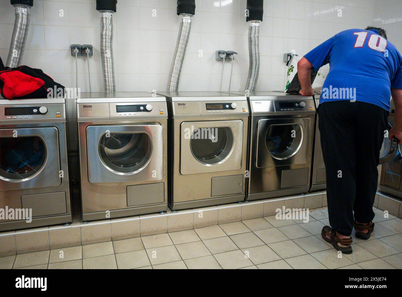 Paris, France, « Miele' Washing Machines Lined up in Laundry Room of Migrant Apartment Building, interiors Stock Photo