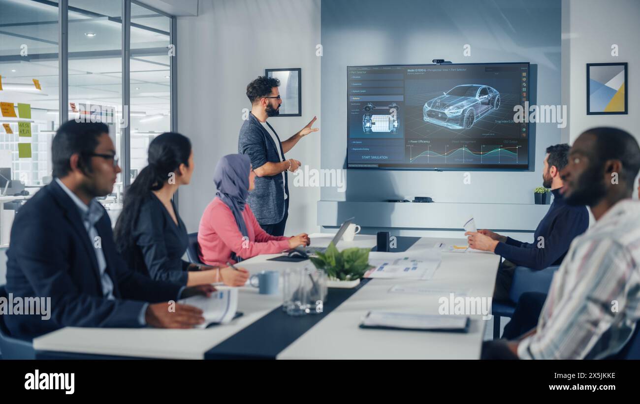 Multi-Ethnic Office Conference Room Meeting: Hispanic Industrial Engineer Presents Car Concept to a team of Technicians Talk, Use TV with 3D Vehicle Prototype Concept. Eco-friendly, Green Energy Stock Photo