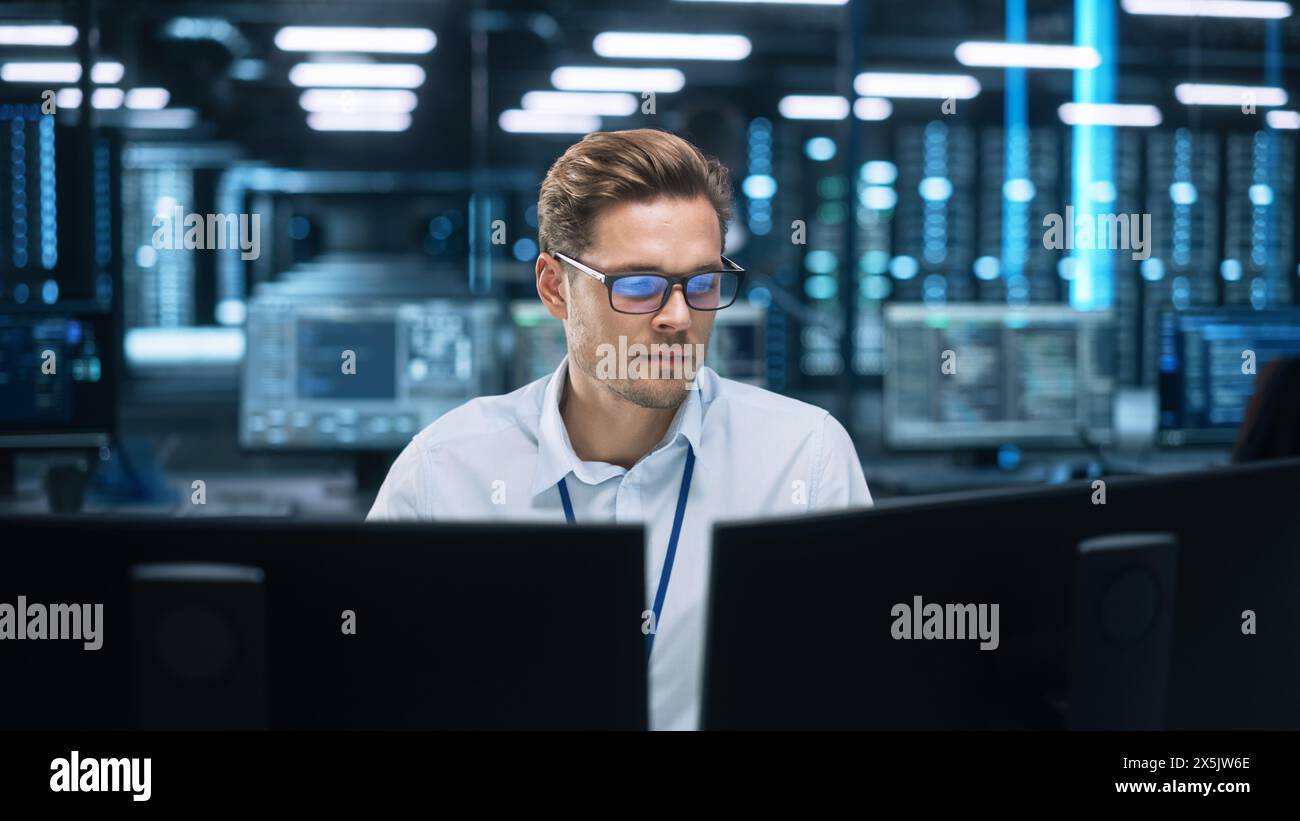 Night Office: Young Caucasian Man Working on Two Desktop Computers. Digital Entrepreneur Typing Code, Creating Modern Software, e-Commerce App Design, e-Business Programming Stock Photo